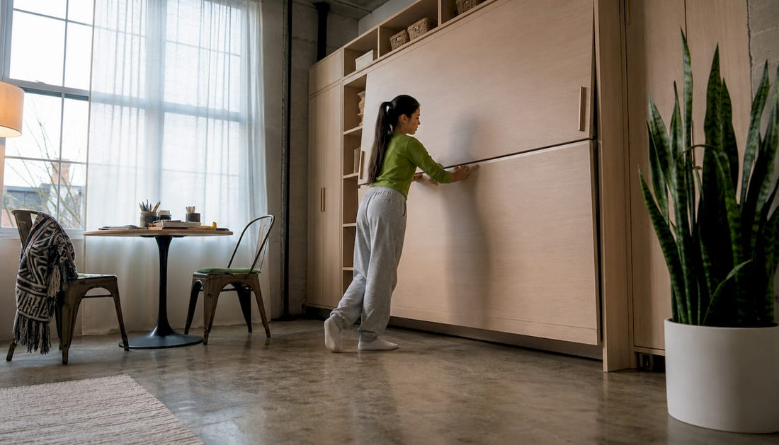 Woman folding Murphy bed in small apartment