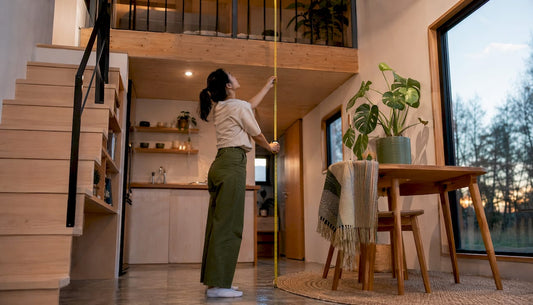 Woman measuring loft in tiny home interior