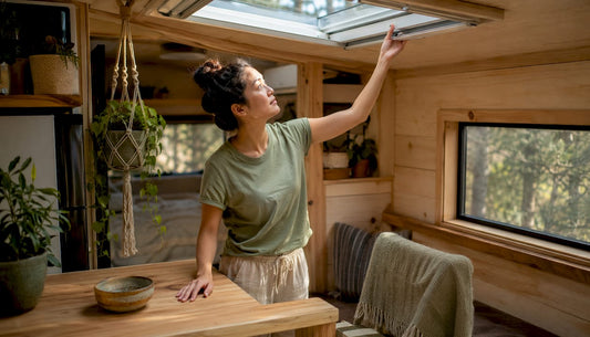 Woman adjusting venting skylight in tiny home